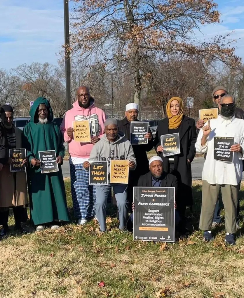 A group of people holding signs in front of trees.