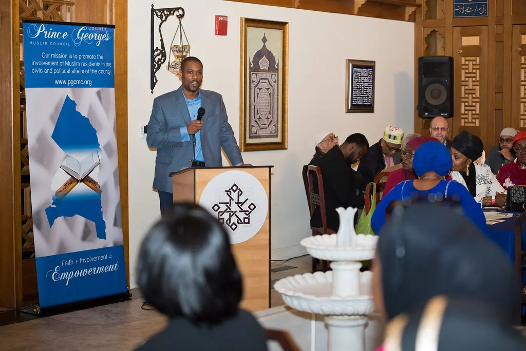 A man speaking at a podium in front of a group of people.